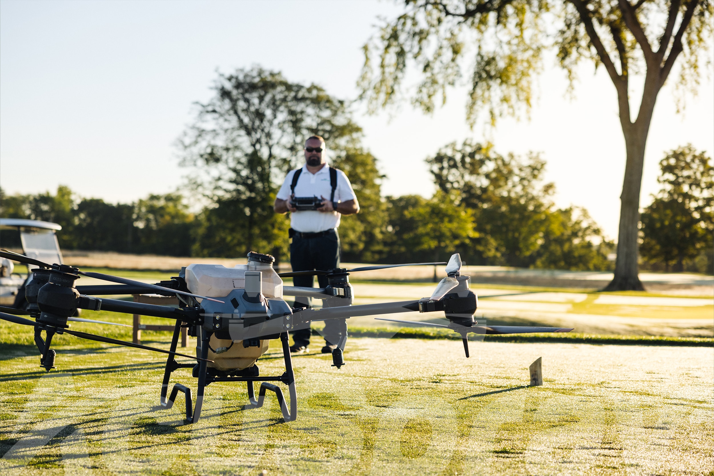 AcuSpray golf course drone service pilot readying drone for takeoff on a tee box.