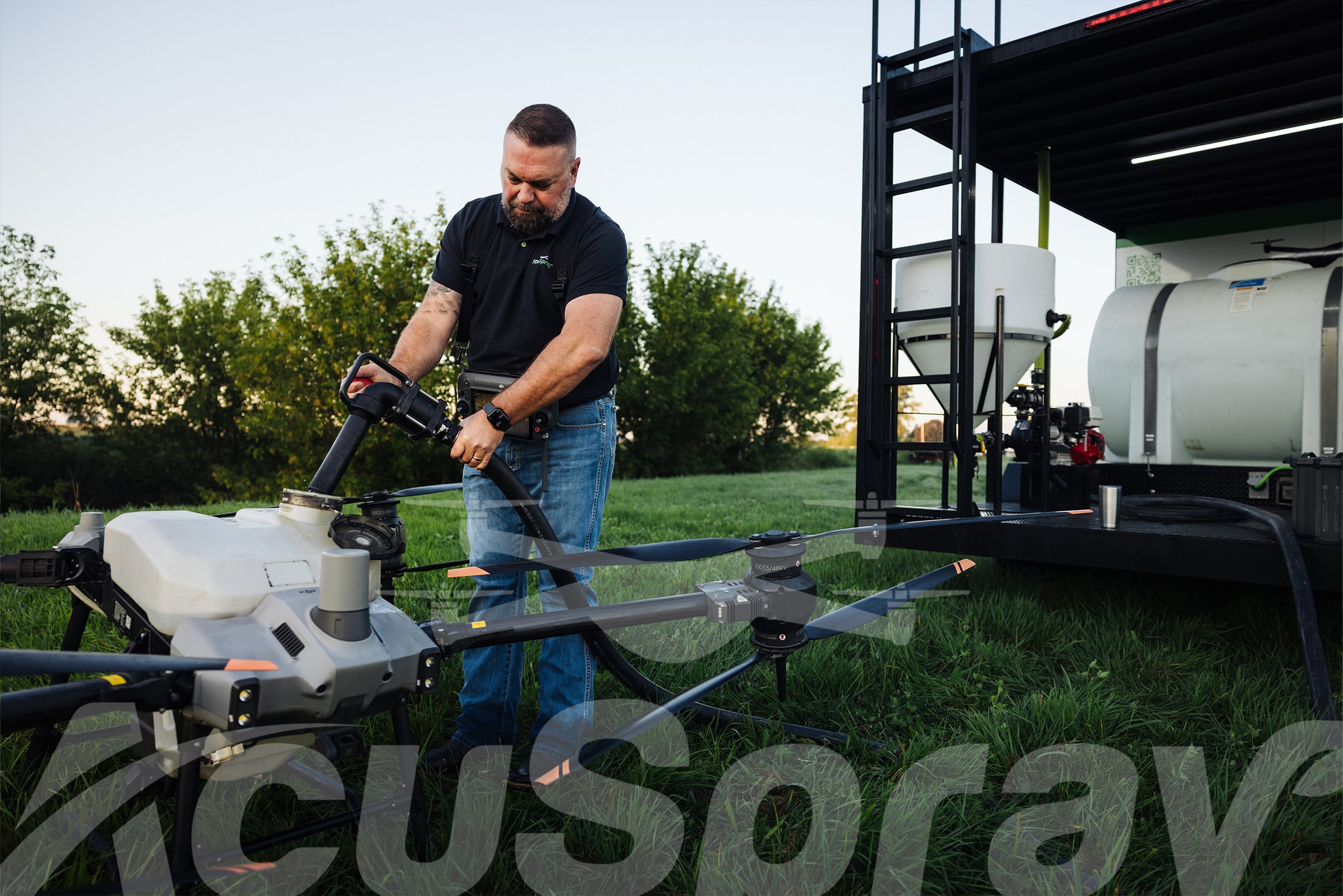 AcuSpray pilot setting up drone spraying services equipment for field treatment.