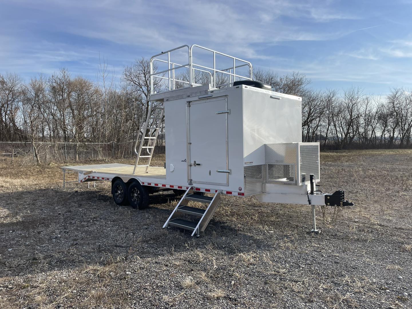 AcuSpray's A450 drone trailer in a field, featuring no-roof structure for easy landings, rear platform for docking, and elevated deck for efficient loading, designed to enhance precision agriculture.